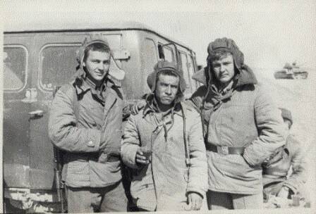 Фотография. Три солдата Советской Армии в ватных фуфайках и шлемах танкистов и БТР.