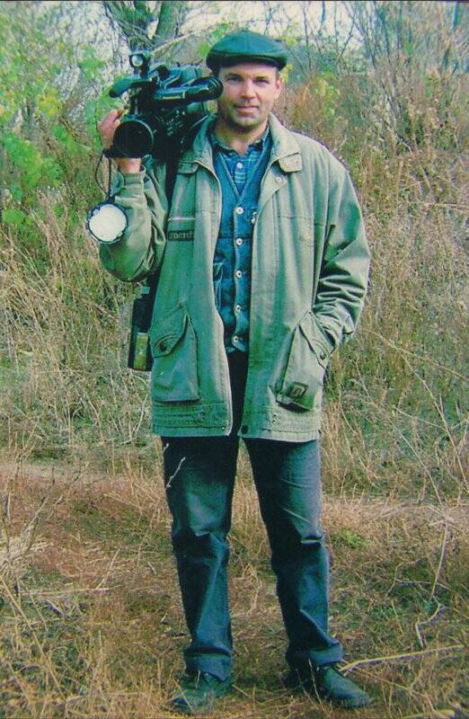 Фотография цветная. Константин Александрович Гвоздь, в полный рост с камерой в руках.