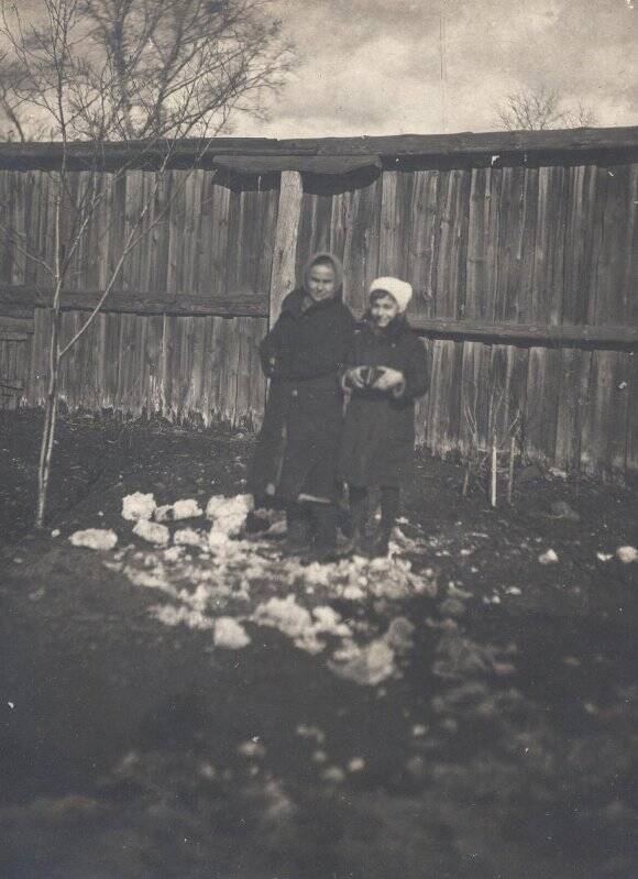 Женщина и девочка на фоне деревянной стены.  04.1938, из коллекции типологических фотографий 1938 года