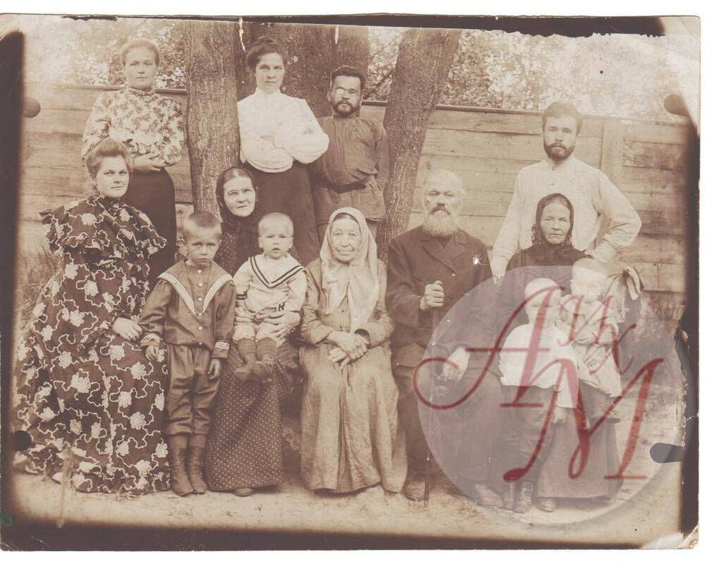 Фотография групповая. Пётр Иванович Цыбышев среди своих детей и внуков во дворе дома.