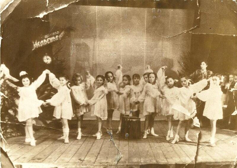 Фотография групповая. Младшие воспитанницы Миловой в момент танца «Артель. «Медвежья услуга» в Доме пионеров.