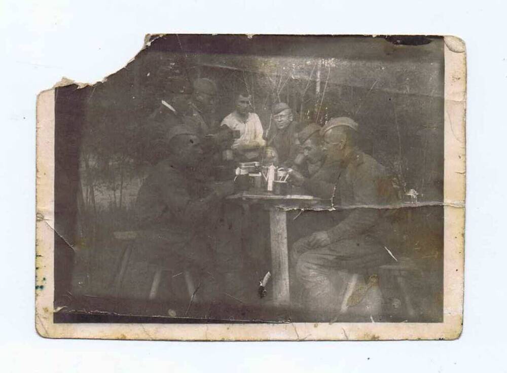 Фотография ч/б групповая: 7 воинов принимают пищу во фронтовой обстановке. Среди них Ефремов Василий Андреевич. 