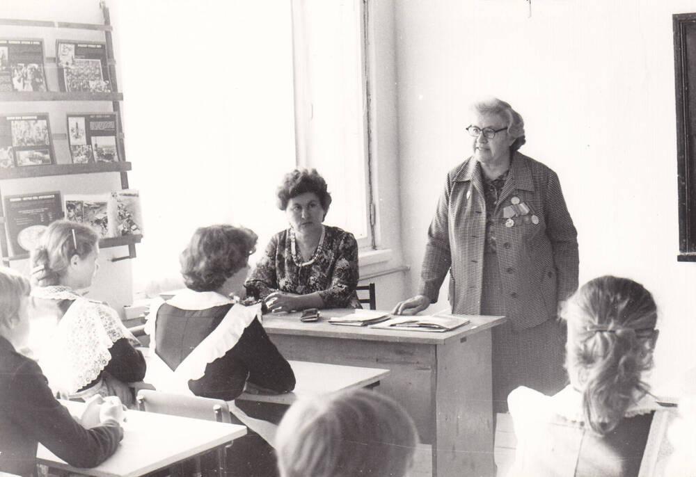 Фото черно-белое. Кислицына Нинель Моисеевна выступает перед учащимися.
