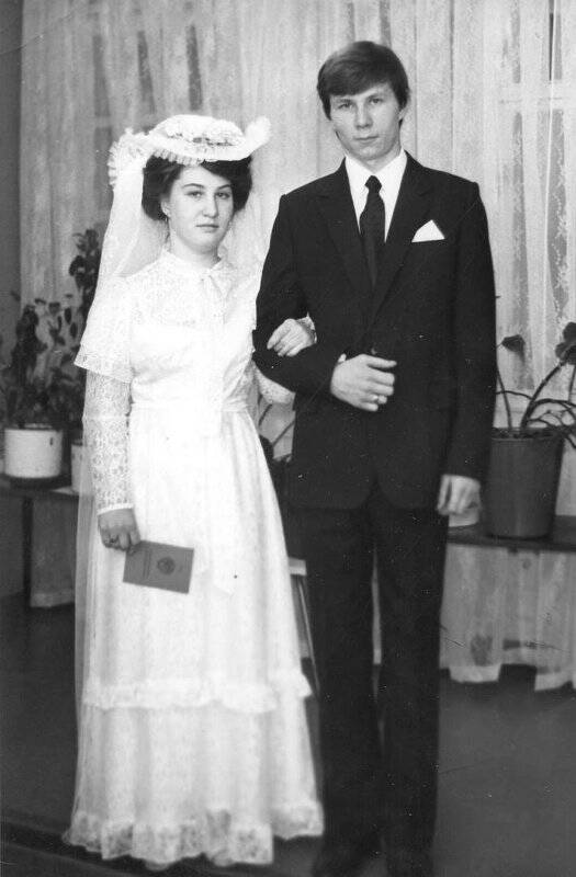 Фотография. Групповое фото (вертикальное). Жених с невестой. У невесты в руке свидетельство о браке.