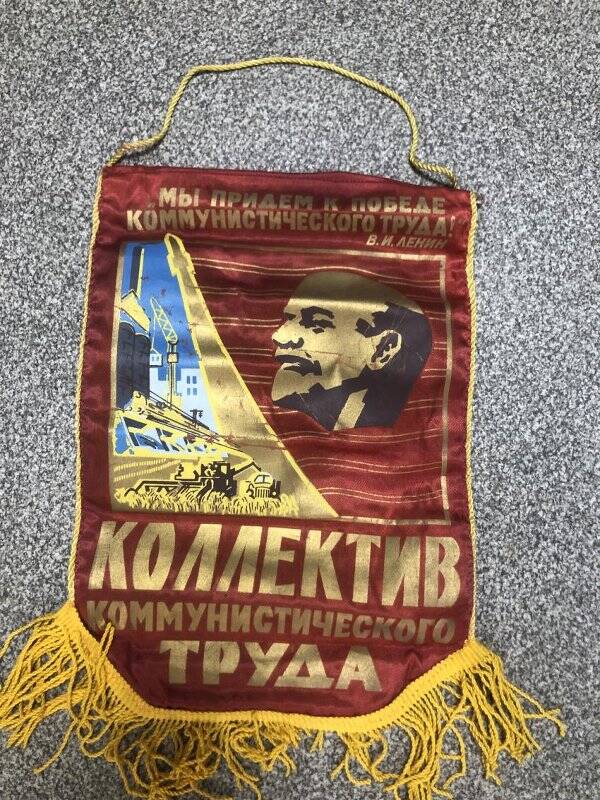 Вымпел с надписью вверху «Мы придем к победе коммунистич труда!» В.И.Ленин; внизу – «Коллектив Коммунист Труда»; в центре - портрет Ленина. Цвет красный с бахромой желтого цвета