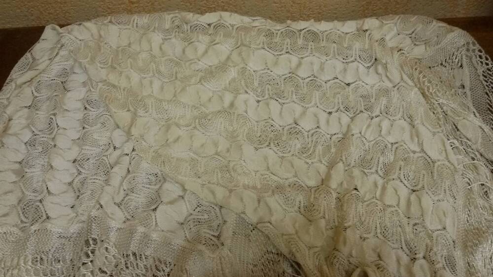 Шаль из шелковой нити молочно-белого цвета с бахромой. Вязка – трикотажный узор «змейка». Фабричного производства.