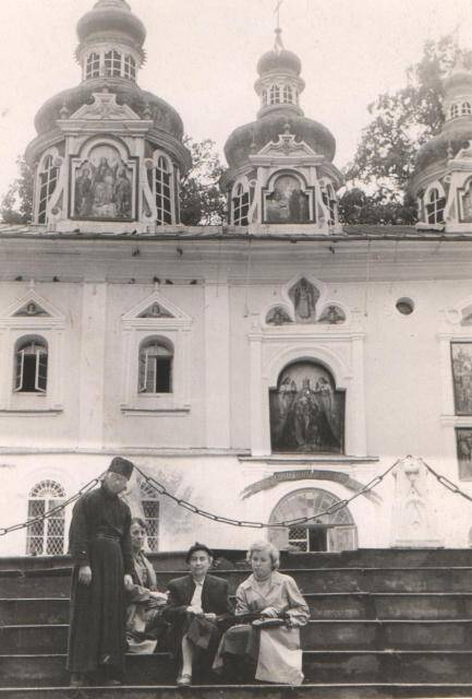 Групповая фотография трех женщин и священника.