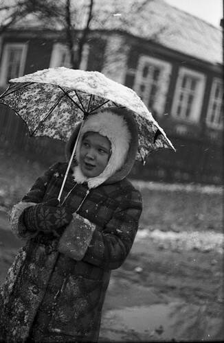 Негатив. В кадре девочка в зимней одежде  под зонтом.