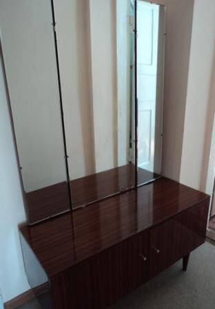 Трельяж - трёхстворчатое зеркало (большое туалетное зеркало в соединении с двумя узкими, боковыми), в сочетании с туалетным столиком в виде коричневой полированной тумбы на ножках
