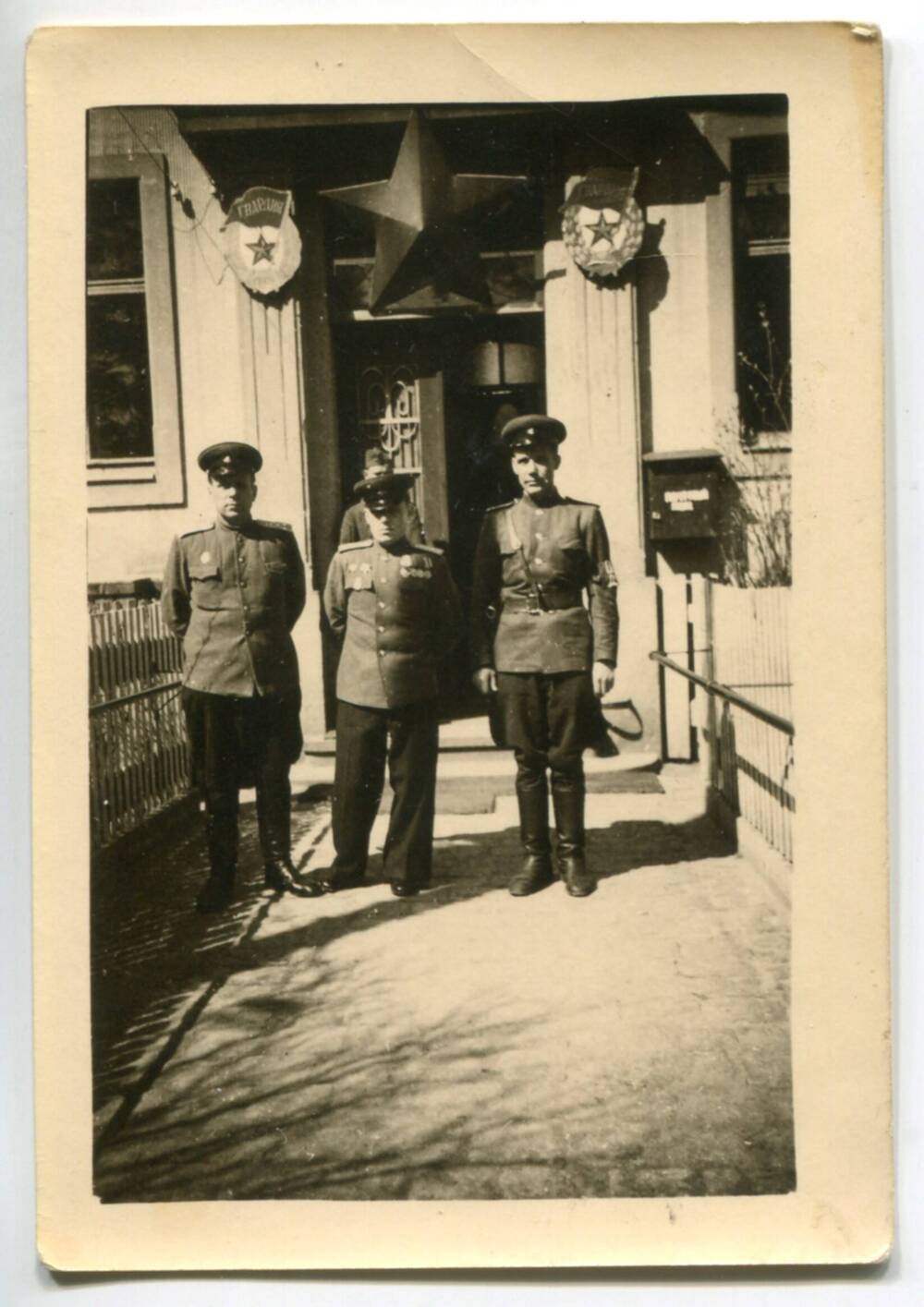 Фотография. Трое военнослужащих около входа в штаб гвардии.