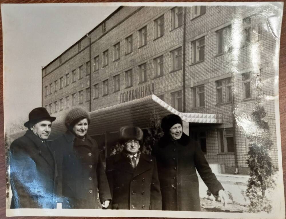 Фотография групповая на фоне здания с надписью Поликлиника. 1983 г.