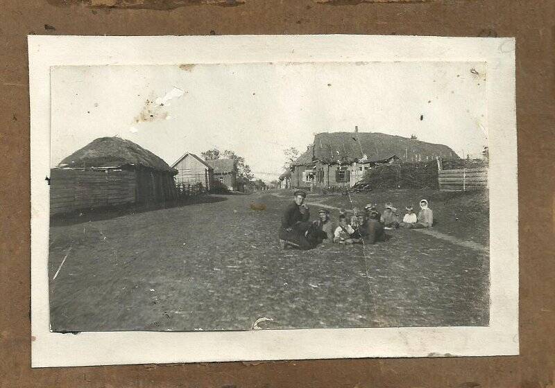 Фотография черно-белая. Представитель органов правопорядка проводит беседу с детьми.