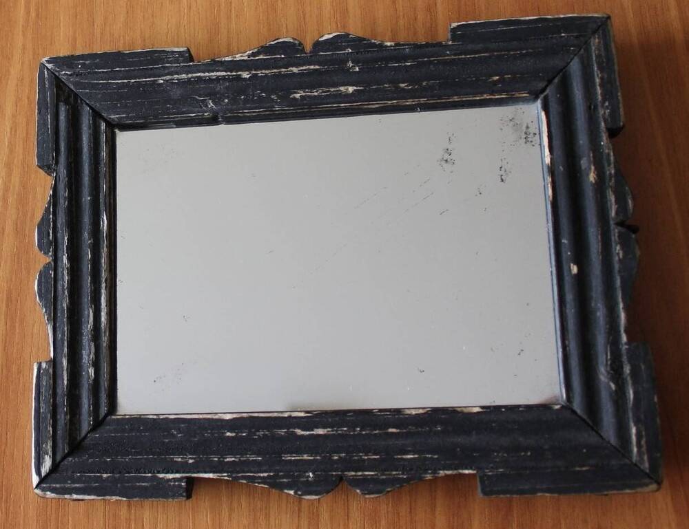 Зеркало в деревянной черной фигурной раме.
