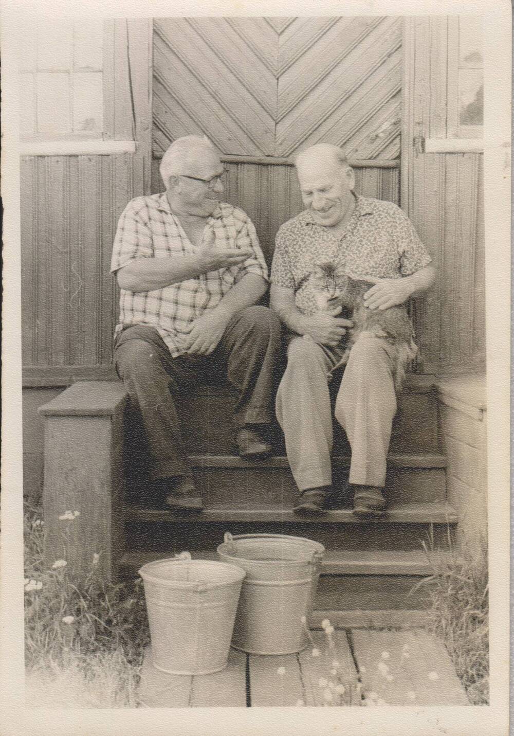 Фотография Лукина Н.И. на крыльце своего дома в д. Устье с кошкой на коленях.
