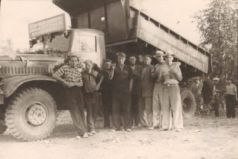 Фотография ч/б Шипова В. С. и жителей поселка Железногорск у машины с первой добытой рудой.