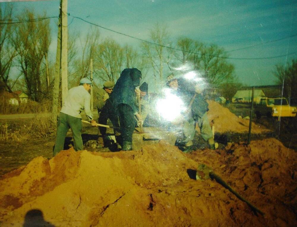 Фотография. Группа мужчин замешивают цементный раствор.