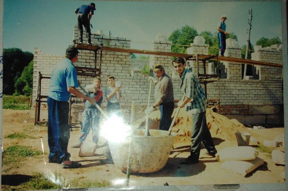 Фотография. Группа мужчин строят мечеть.