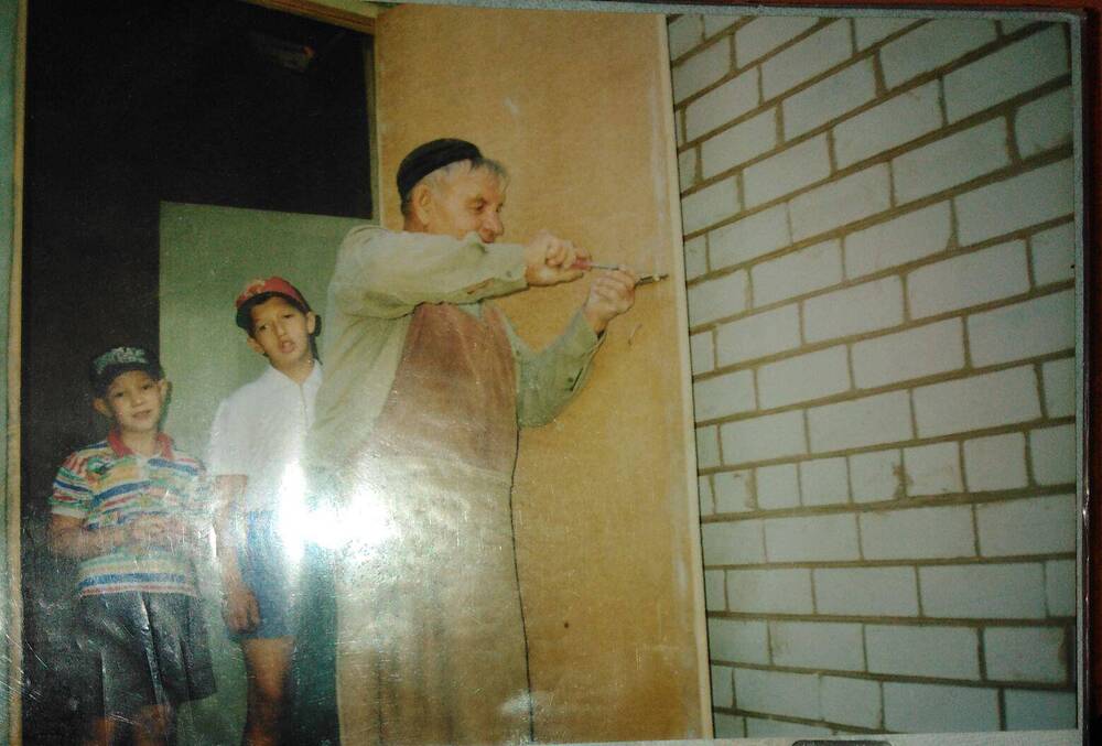 Фотография. Муллагалиев Ж. и его внуки ремонтируют дверь
