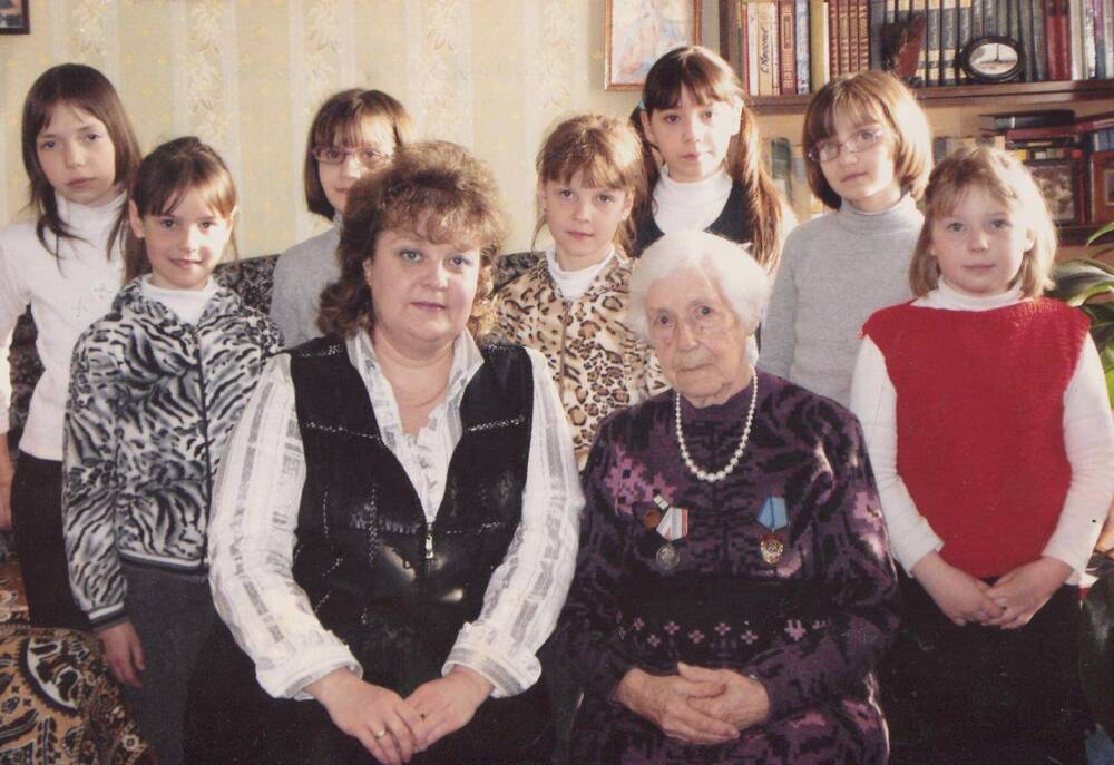 Фото цветное. Л.М.Леонтьева (сидит справа) с учащимися музыкальной школы.