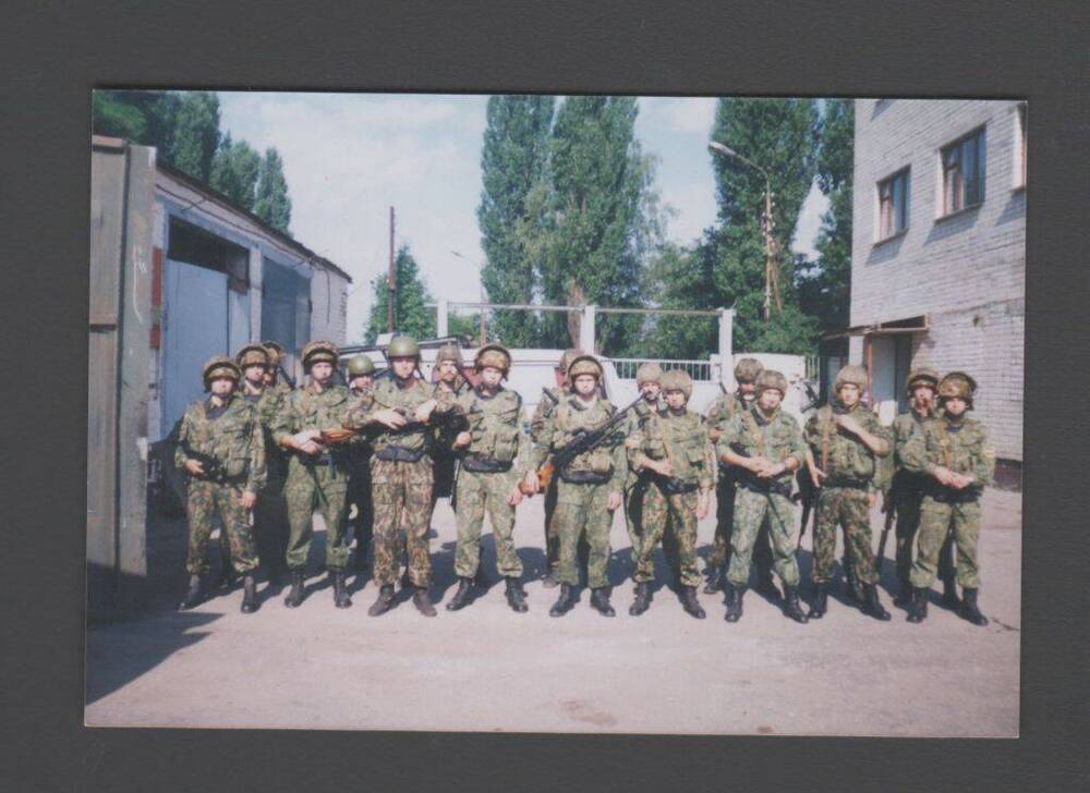 Фотография - групповой цветной снимок. Восемнадцать солдат в форме защитного цвета, в касках, с оружием в руках - бойцы ОМОНа ГУВД Ставропольского края.