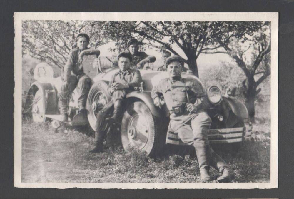 Фотография ч/б - сюжетный снимок. Четверо мужчин в военной форме без погон сидят на легковом автомобиле довоенного производства. Первый справа с фотоаппаратом фотокорреспондент С.М.Петросян. 1941 год.