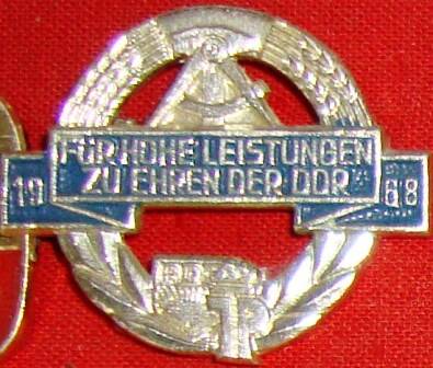 Значок, надпись на иностранном языке:FURHOHE LEISTUNGEN ZU ENPEN DER DDR.