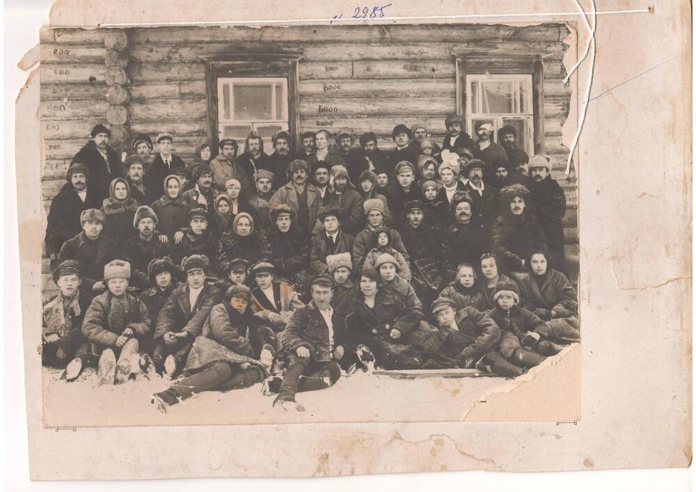 Фотография - Группа людей в зимней одежде на фоне деревенского дома