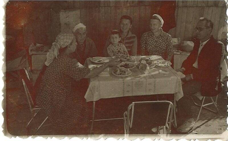 Фотография черно-белая. Айше Махмудовна за столом с родными. Из личного архива Рефатовой Айше Махмудовны