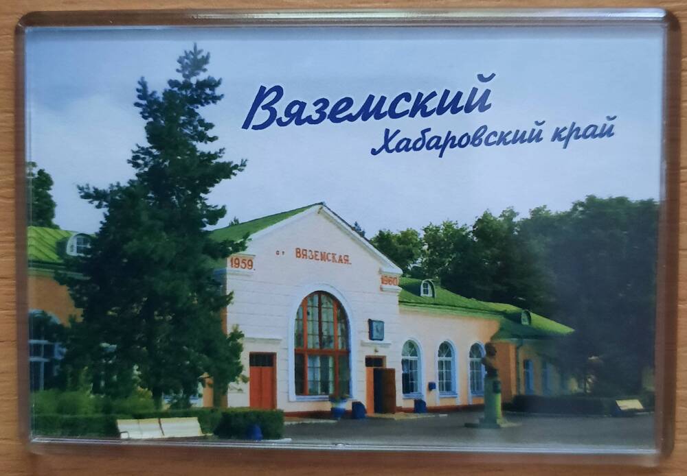 Магнит сувенирный «Вяземский Хабаровский край» с изображением привокзальной площади и здания железнодорожного вокзала станции Вяземская.
