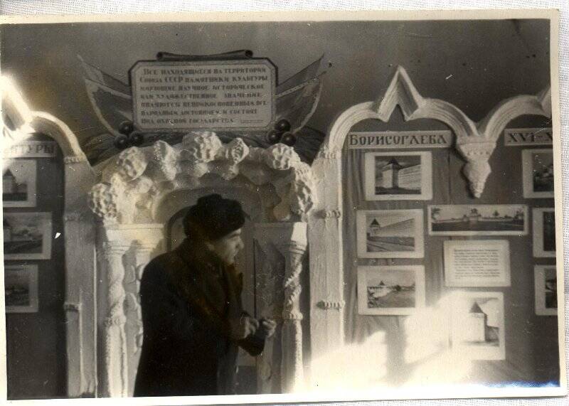 Фотография. В.С. Баниге возле стендов с фотографиями Борисоглебского монастыря.