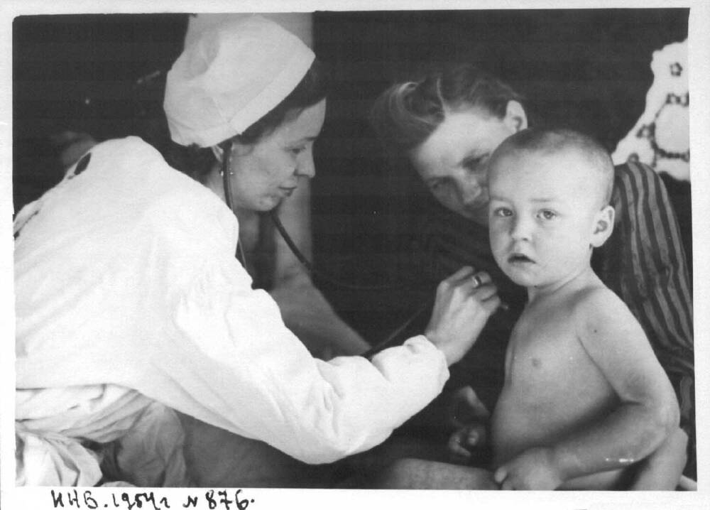 Фотография. Оказание скорой медицинской помощи на дому. Врач Нарожных З.П. осматривает больного ребенка.