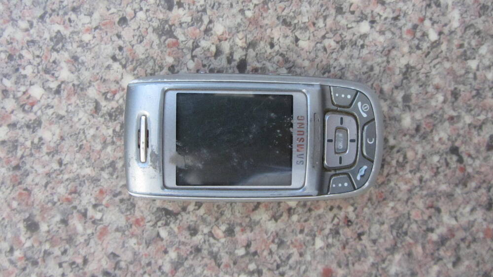 Телефон мобильный “Samsung SGH-E350”, в корпусе-слайдере серебристого цвета. Компания “Samsung”