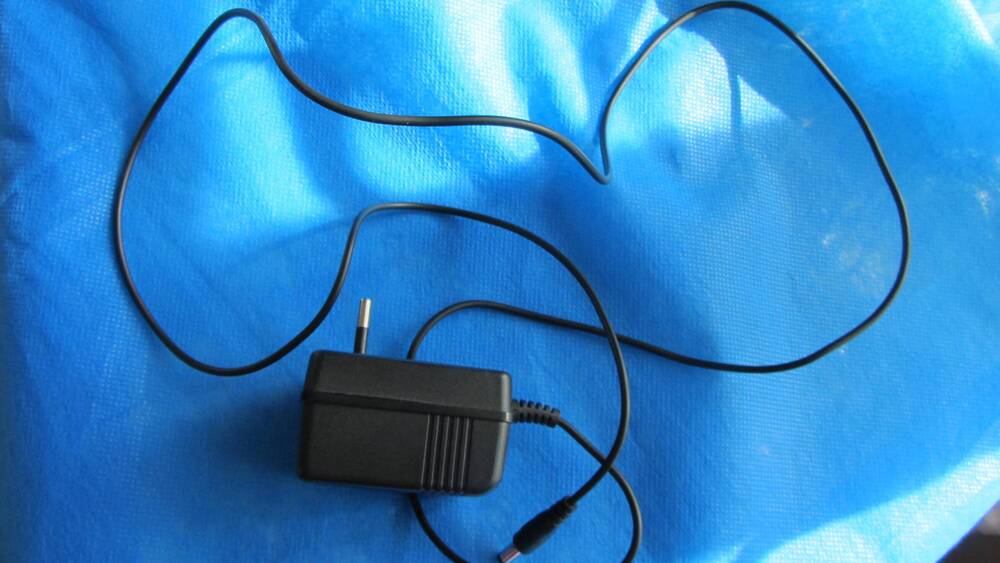 Адаптер сетевой к игровой приставке Simba’s Mega Pauer II, в корпусе чёрного цвета.