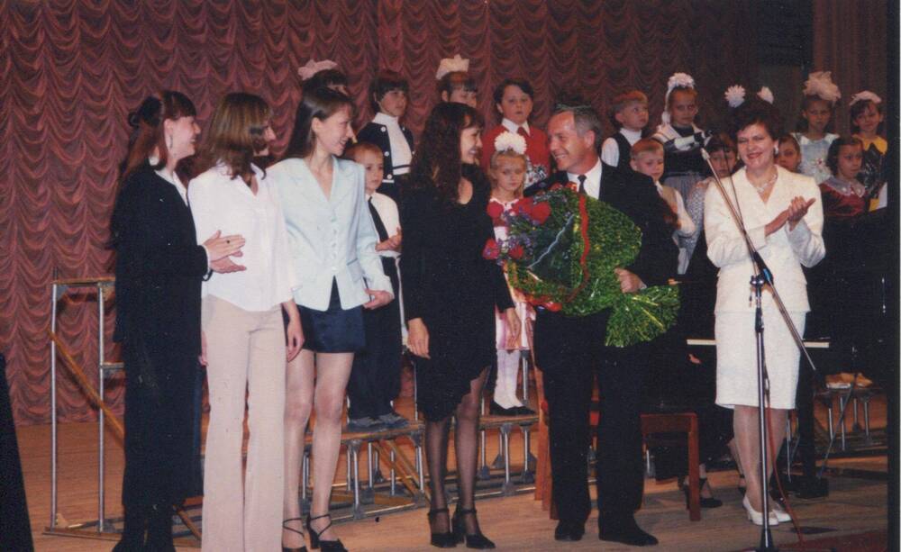 Фото цветное групповое,Михайлусов В.И. с букетом цветов,справа от него Жукова Л.В. начальник управления по делам  культуры и искусства 