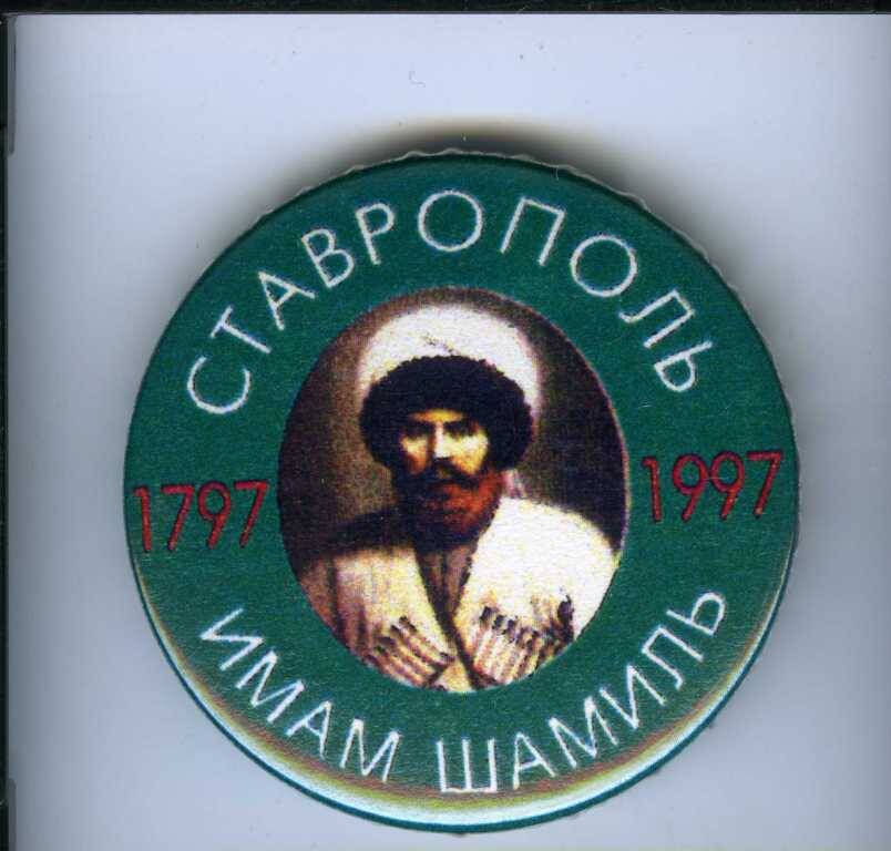 Значок нагрудный круглой формы, в центре портрет Имама Шамиля, по краю на зеленом фоне надпись Ставрополь. Имам Шамиль. 1797-1997 гг.