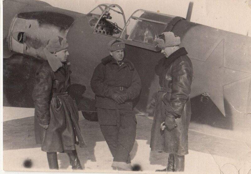 Группа авиаторов у самолета зимой.