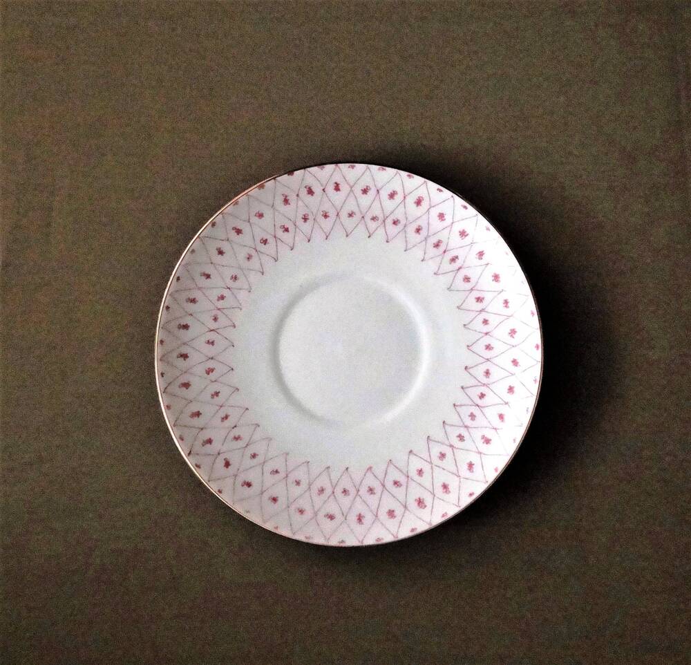Кофейная пара. Блюдце мелкое круглой формы с ровным краем белого цвета, по борту сетчатый орнамент розового цвета и полоса позолоты.