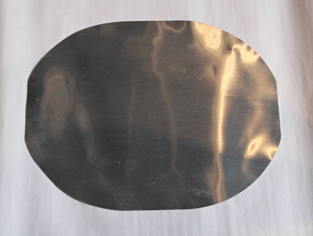 Лист алюминиевый в форме усечённого с двух сторон овала.