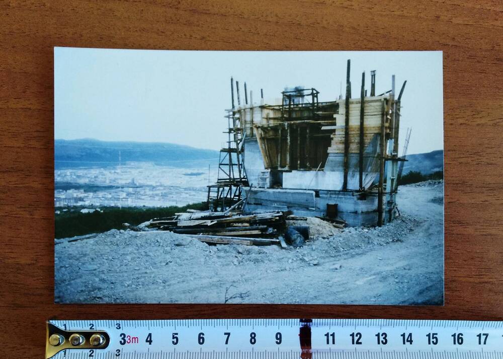 Фотография цветная, глянцевая печать, строительство монумента «Маска Скорби», вид нижней обратной части монумента, окруженный строительными лесами, г. Магадан, 1990-е гг.