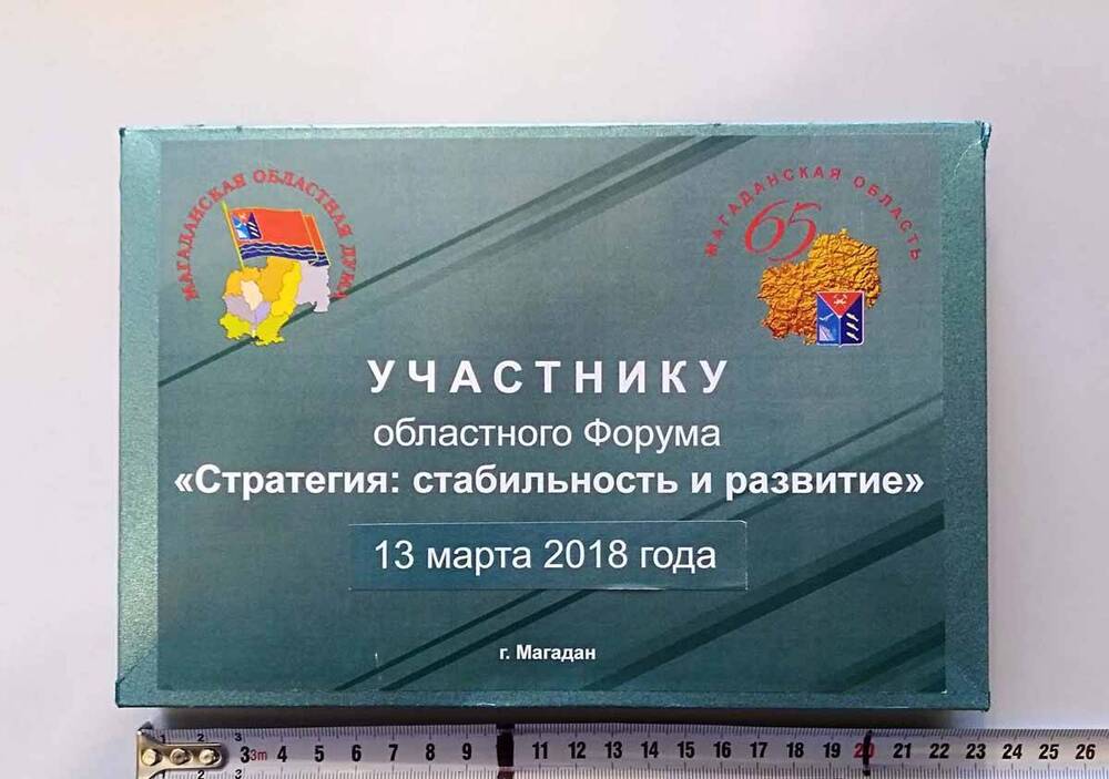 Папка картонная, зеленого цвета, на лицевой стороне надпись: «Участнику областного Форума «Стратегия: стабильность и развитие» 13 марта 2018 года, г. Магадан»