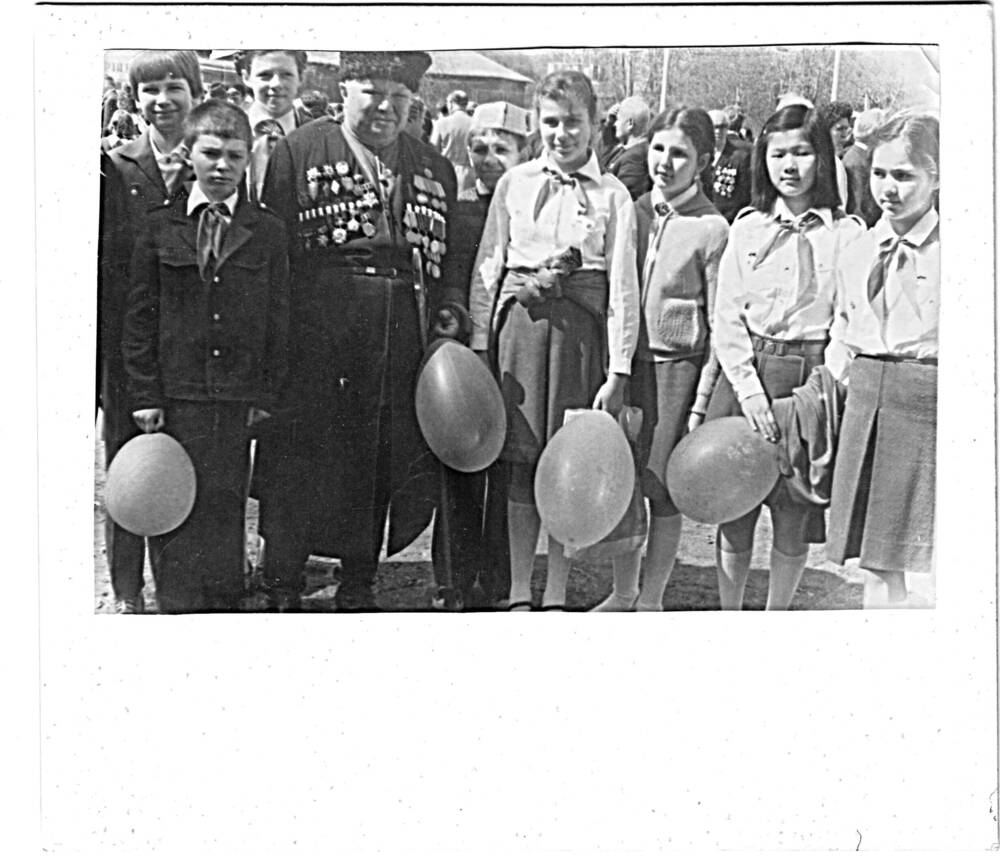 Фотография черно-белая Кузякина Павла Николаевича, ветерана 4 ГКККК, среди группы школьников в пионерских галстуках.