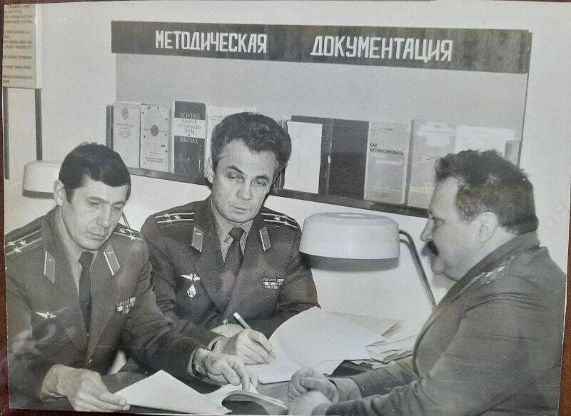 Фотография. В учебном - летном отделе сидят за столом трое военных. Слева 1 - ый - Мирзеев Рафаиль Шамсимухаметович. 1983 - 1985г.г.