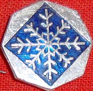 Значок многоугольной формы с изображением снежинки.