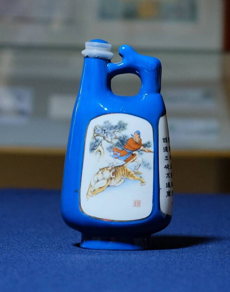 Сосуд синего цвета для национального напитка.На белом фоне надписи на китайском языке,изображение битвы  воина и тигра. 