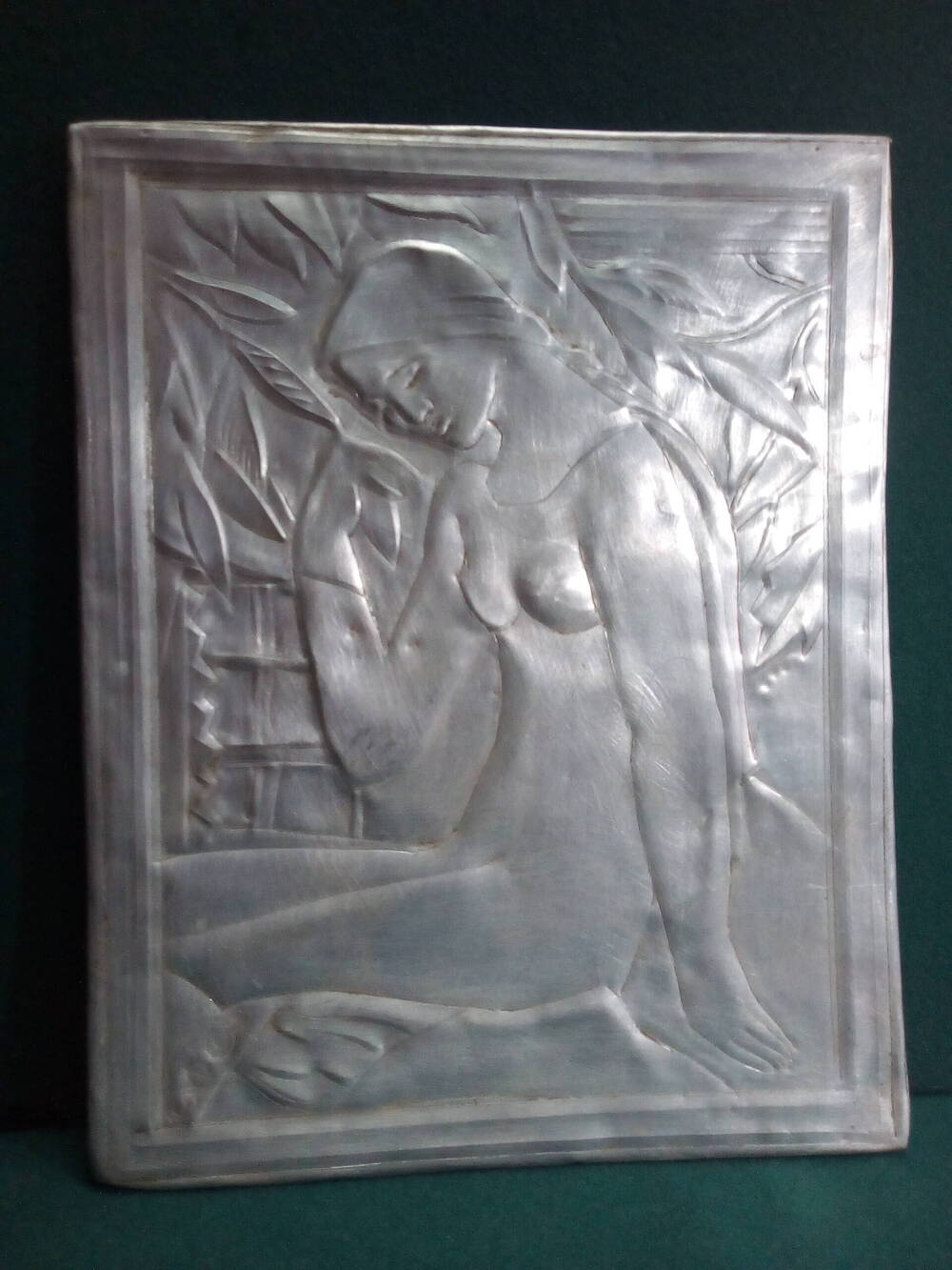 Чеканка из металла с изображением сидящей девушки