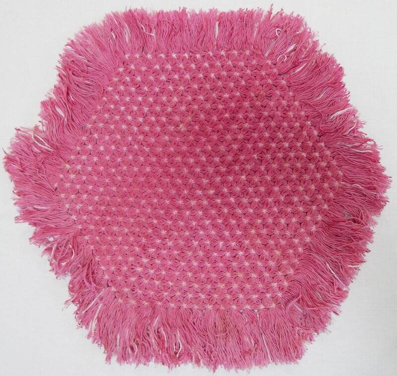 Салфетка розового цвета, плетеная на шестиугольной раме в стиле тенериф, с бахромой.