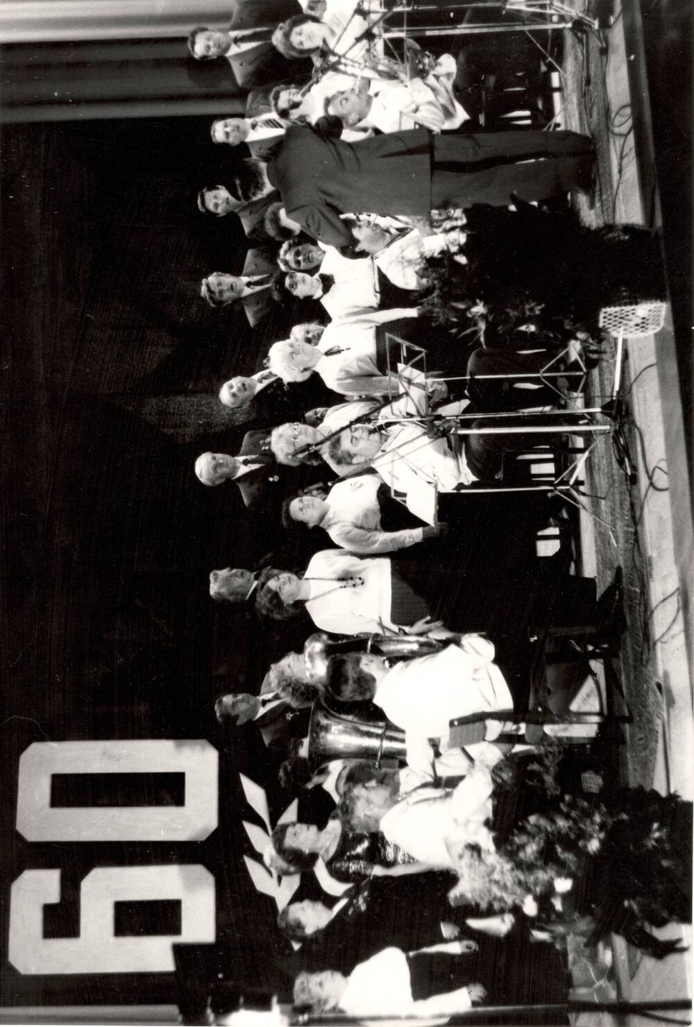 Фотография черно-белая, посвящена празднованию 60- летия Ефремовского завода СК.Выступление хора ветеранов завода с духовым оркестром.