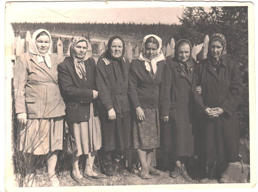Группа из шести женщин стоят на фоне деревянного забора, первая справа Юдина Екатерина Федоровна.