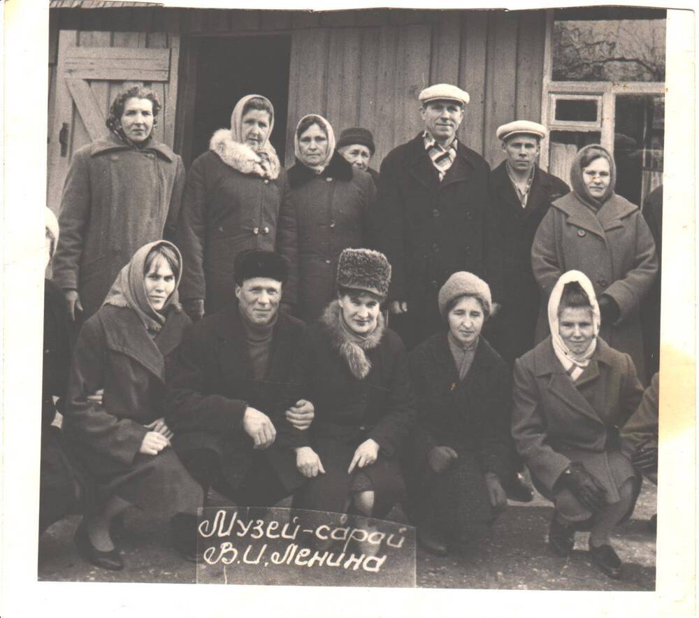 Группа мужчин и женщин в зимней одежде на фоне деревянного здания Музей- сарай В.И.Ленина город Ленинград. 2-ая справа верхний ряд: Юдина Екатерина Федоровна. 