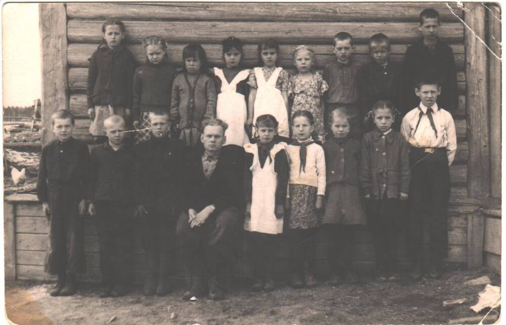 Группа учеников начальной школы в центре сидит учитель Николай Васильевич, поселок Сельхоз-Шежам, Усть-Вымский район, Коми АССР. 